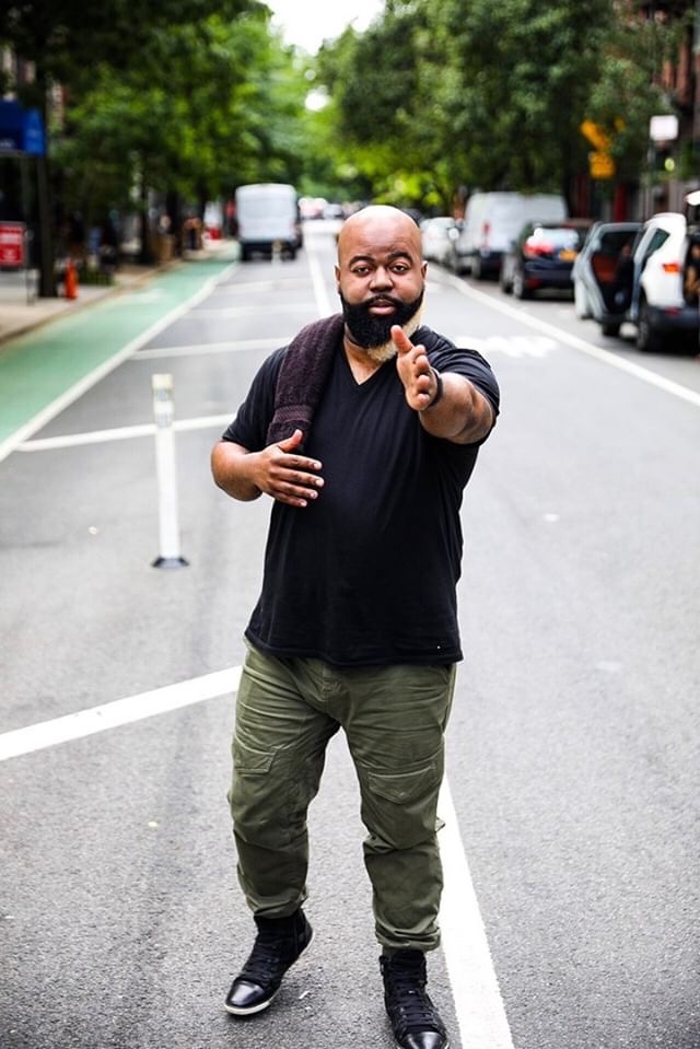 C. Anthony Bryant standing in the middle of a New York City street pointing towards the camera